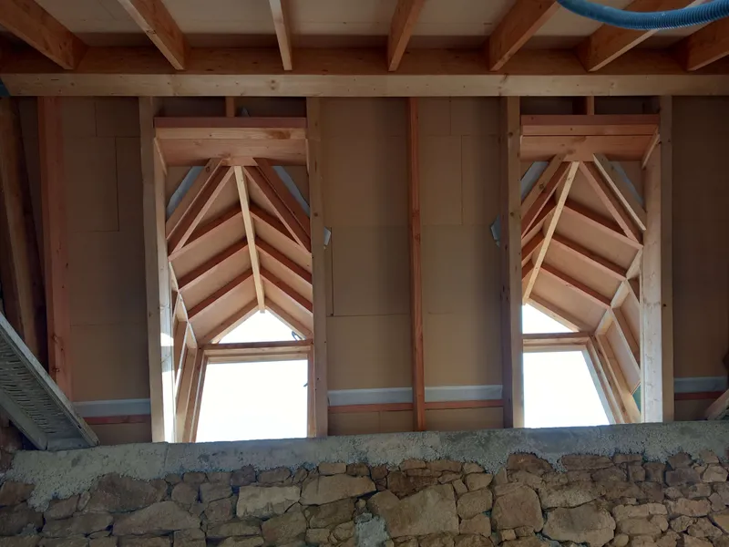 Travaux de charpente avec lucarnes après couverture vus de l'intérieur